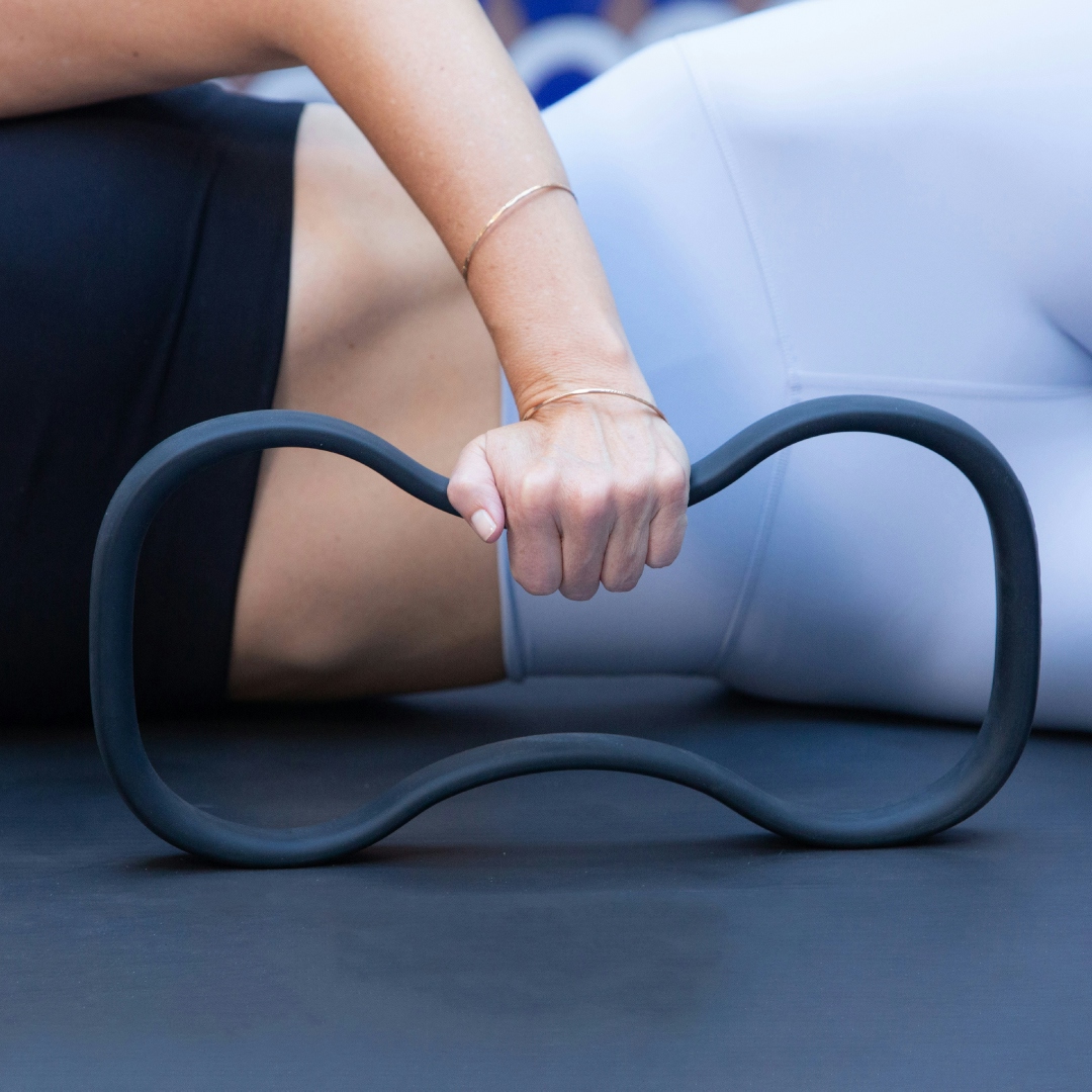 A woman is working out with a reimagined fitness ring from the brand WundaCore.